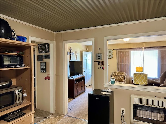 712 1st St, Maysville, OK 73057 - kitchen with heating unit, stainless steel microwave, and light colored carpet