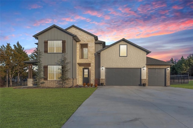view of front of home with a front yard, an attached garage, board and batten siding, fence, and driveway