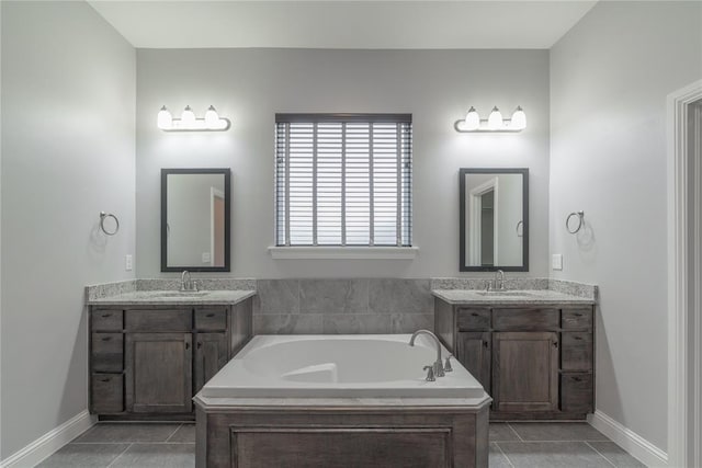 full bathroom featuring a garden tub, two vanities, a sink, and tile patterned flooring