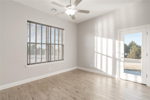 unfurnished room with a healthy amount of sunlight, light wood finished floors, and visible vents