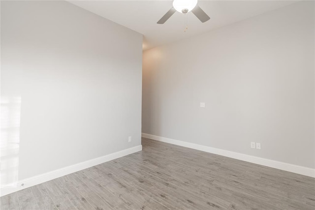 spare room featuring light wood-style floors, baseboards, and a ceiling fan
