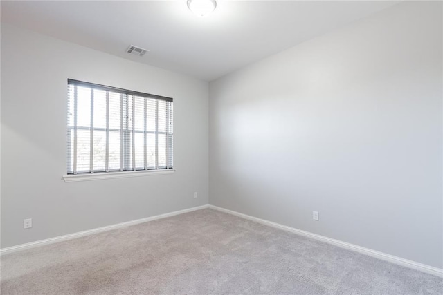 spare room with baseboards, carpet, and visible vents