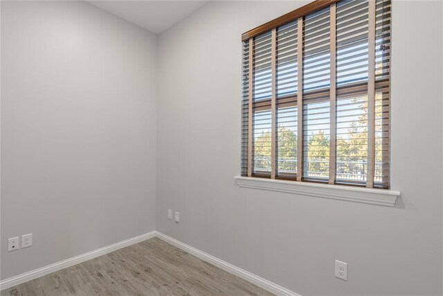 spare room with wood finished floors and baseboards