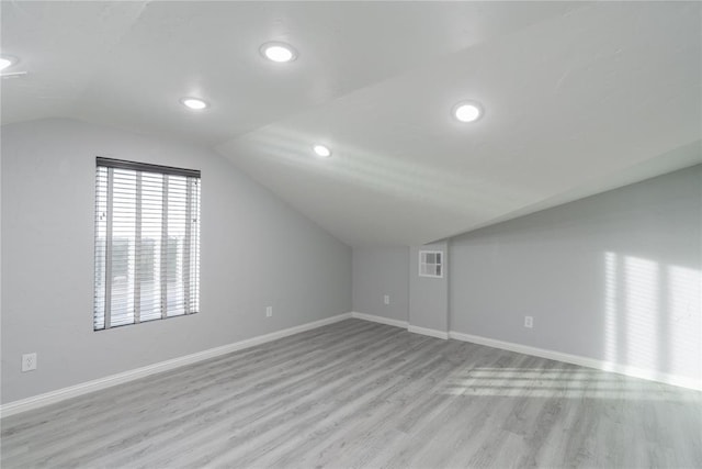 additional living space with visible vents, baseboards, light wood-type flooring, recessed lighting, and lofted ceiling