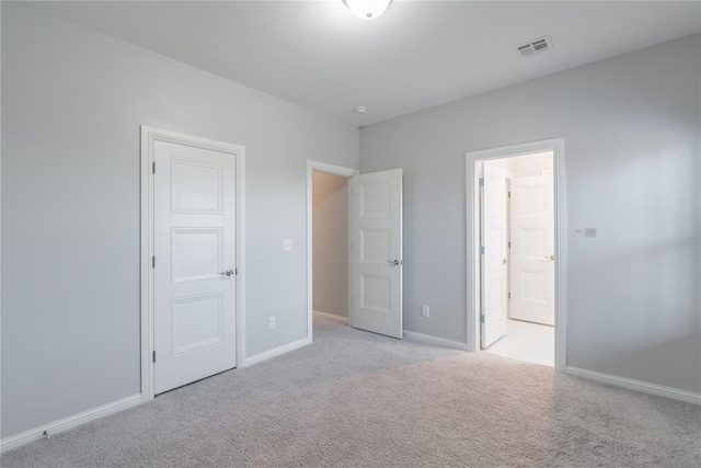 unfurnished bedroom featuring visible vents, light colored carpet, and baseboards