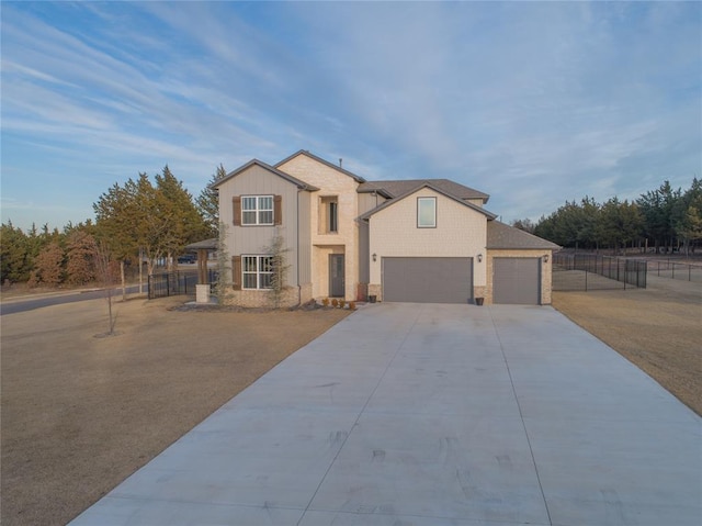 traditional-style house featuring concrete driveway, stone siding, fence, and a garage