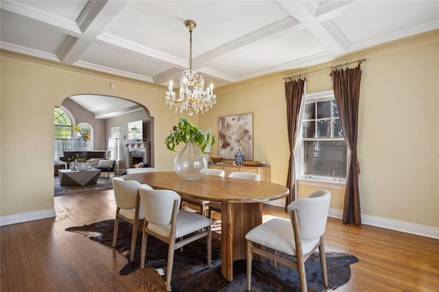 500 NW 41st St, Oklahoma City, OK 73118 - dining room with a lit fireplace, arched walkways, hardwood / wood-style floors, coffered ceiling, and baseboards