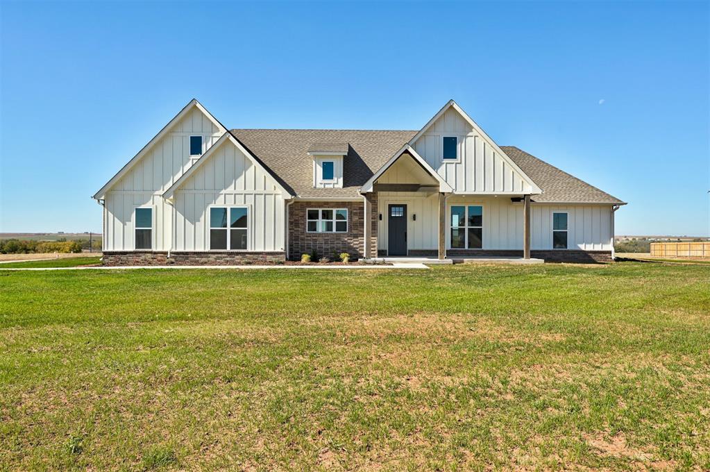 4177 Pinon Ln, Piedmont, OK 73078 - modern farmhouse style home with a front yard, roof with shingles, and board and batten siding