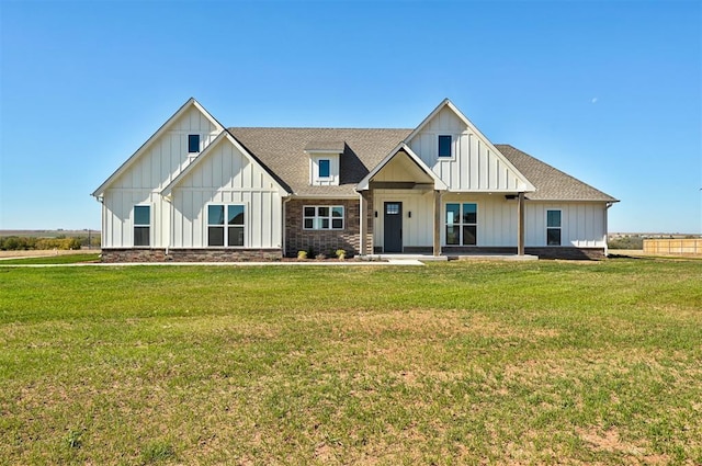 modern farmhouse style home with a front yard, roof with shingles, and board and batten siding