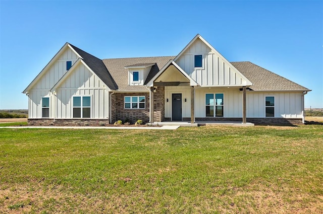 modern farmhouse style home with a front yard, roof with shingles, and board and batten siding