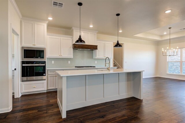 kitchen featuring visible vents, stovetop, a sink, oven, and built in microwave