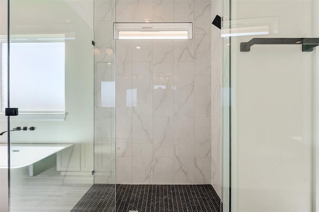 bathroom featuring a shower stall and a soaking tub