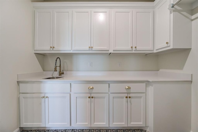 interior space featuring light countertops, a sink, and white cabinetry