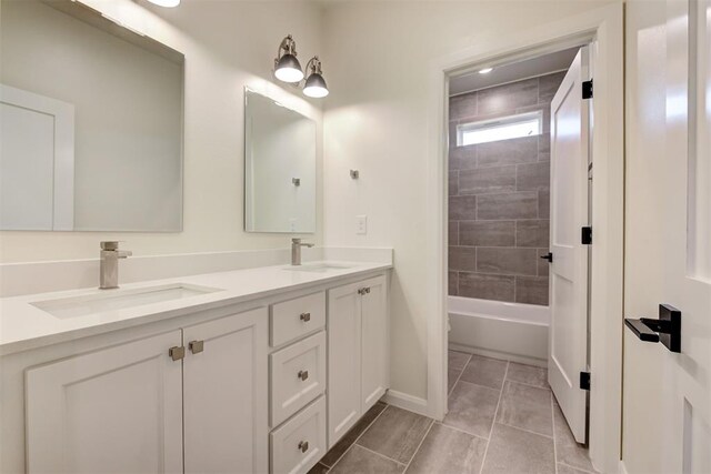 full bathroom with tile patterned flooring, double vanity, baseboards, and a sink