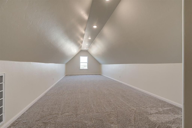 bonus room with baseboards, recessed lighting, a textured ceiling, lofted ceiling, and light colored carpet