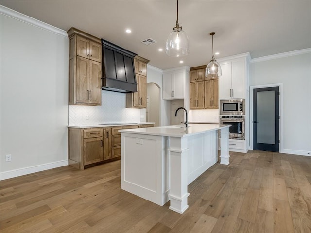 kitchen featuring decorative backsplash, light wood finished floors, visible vents, and stainless steel appliances