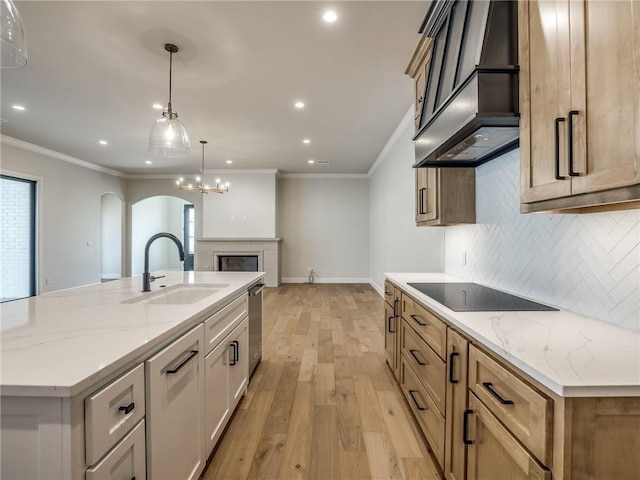 kitchen featuring tasteful backsplash, arched walkways, a sink, premium range hood, and black electric cooktop