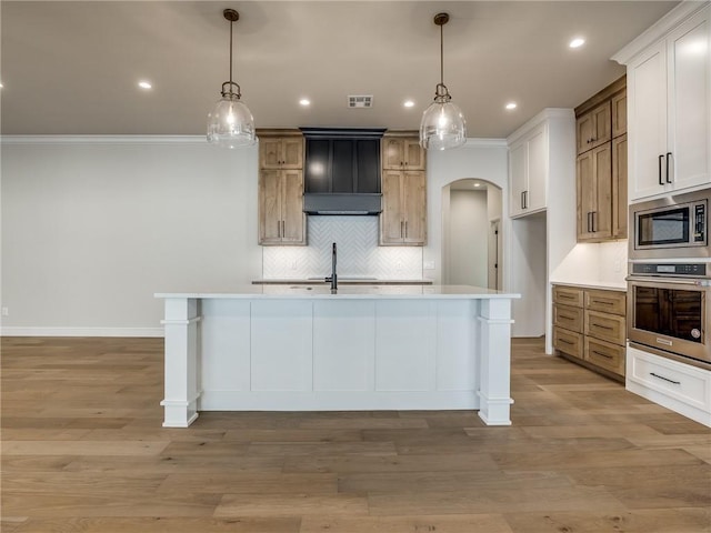 kitchen with visible vents, light countertops, crown molding, stainless steel appliances, and backsplash