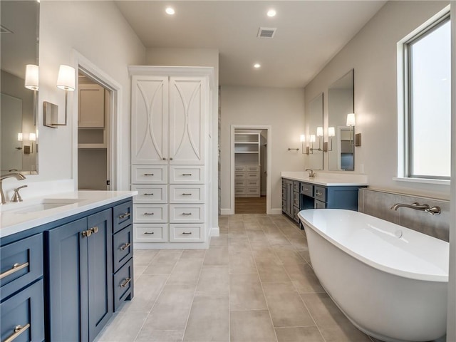 bathroom with two vanities, visible vents, recessed lighting, a sink, and a freestanding bath