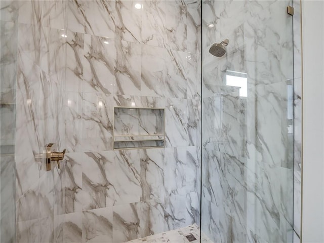 bathroom featuring a marble finish shower