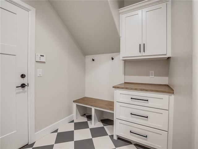 mudroom featuring tile patterned floors, baseboards, and vaulted ceiling
