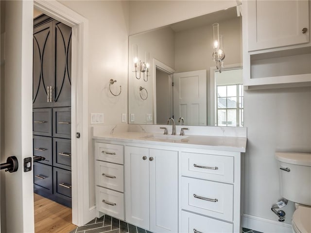 bathroom with vanity, baseboards, toilet, and wood finished floors