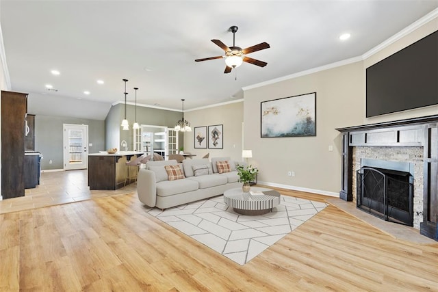 9233 SW 48th Ter, Oklahoma City, OK 73179 - living area featuring baseboards, a stone fireplace, ornamental molding, light wood finished floors, and ceiling fan with notable chandelier