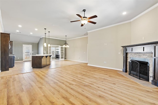 9233 SW 48th Ter, Oklahoma City, OK 73179 - unfurnished living room featuring light wood-style floors, ceiling fan with notable chandelier, crown molding, and a stone fireplace