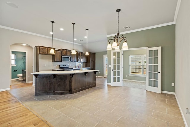 9233 SW 48th Ter, Oklahoma City, OK 73179 - kitchen featuring french doors, light countertops, visible vents, appliances with stainless steel finishes, and arched walkways