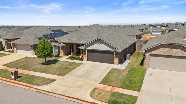 9233 SW 48th Ter, Oklahoma City, OK 73179 - view of front facade with a residential view, a front yard, an attached garage, a shingled roof, and concrete driveway