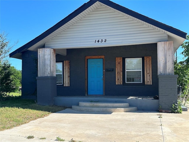 1432 NE 12th St, Oklahoma City, OK 73117 - bungalow featuring a porch and brick siding