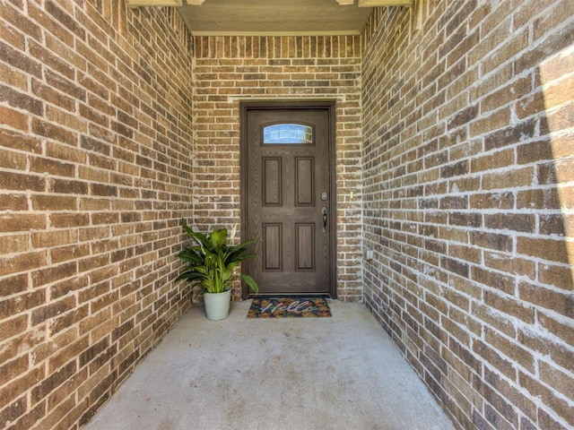 view of exterior entry with brick siding