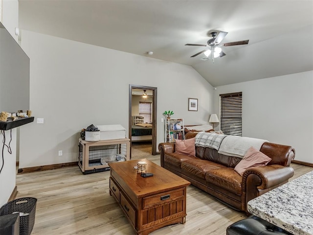 living area featuring light wood-style flooring, baseboards, a ceiling fan, and lofted ceiling