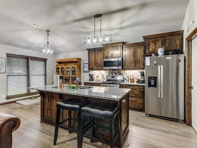 kitchen featuring a sink, light wood-type flooring, appliances with stainless steel finishes, and a chandelier