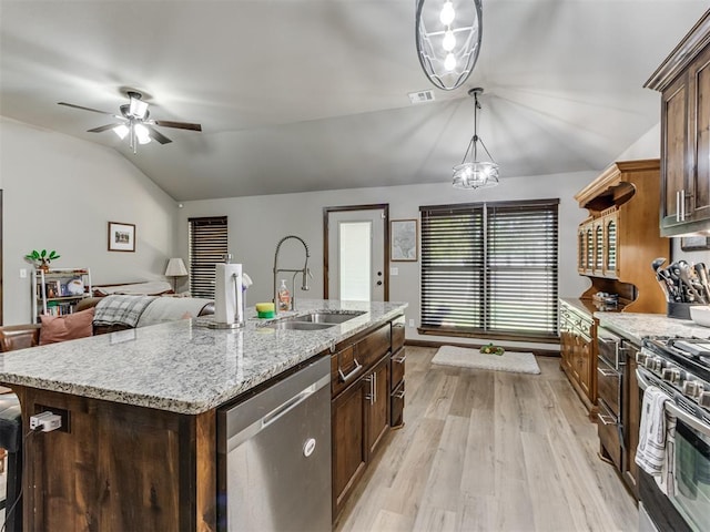 kitchen with a sink, ceiling fan, light wood-type flooring, appliances with stainless steel finishes, and vaulted ceiling