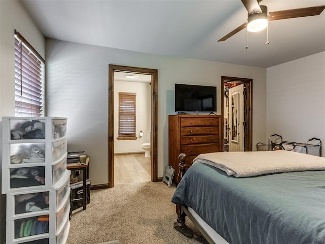 bedroom featuring light colored carpet, baseboards, a ceiling fan, and connected bathroom