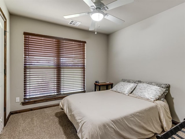 carpeted bedroom with baseboards, a ceiling fan, and visible vents