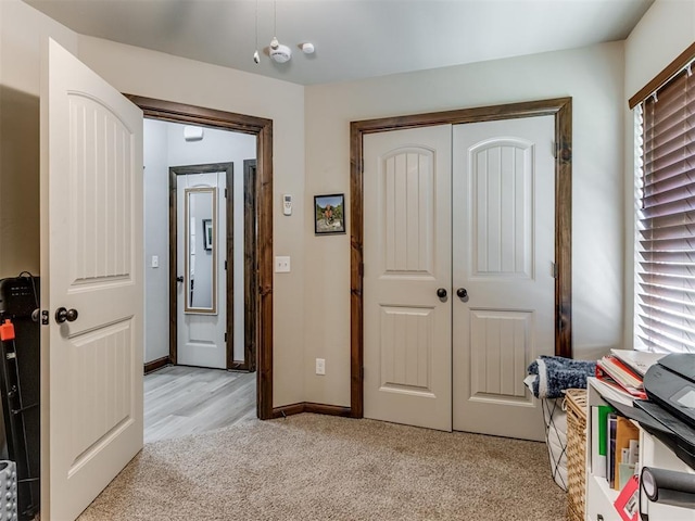 interior space featuring light carpet and baseboards