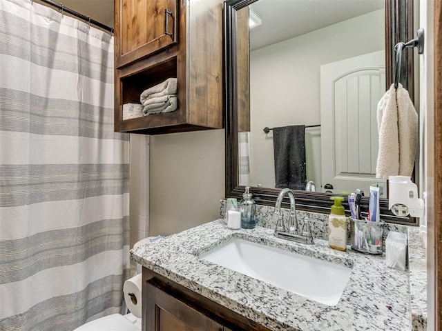 bathroom with toilet, vanity, and a shower with curtain