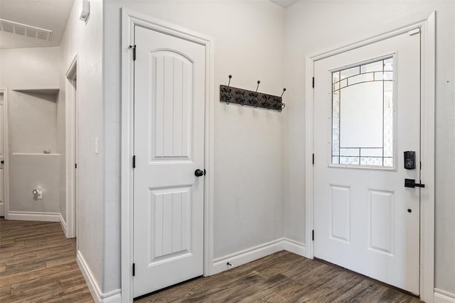 foyer entrance featuring visible vents, baseboards, and dark wood finished floors