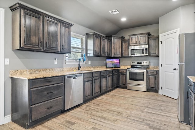 kitchen with light wood-style floors, dark brown cabinets, visible vents, a sink, and stainless steel appliances