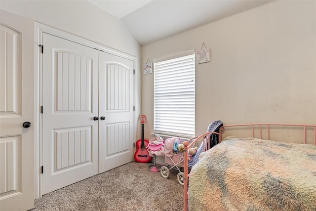 carpeted bedroom with a closet and lofted ceiling