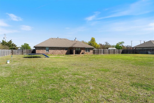 view of yard featuring a trampoline and a fenced backyard