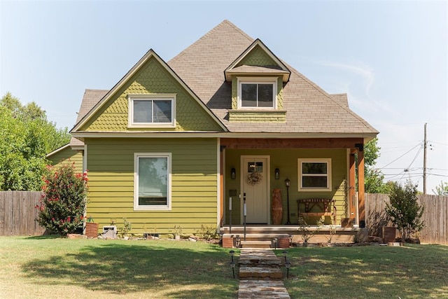 view of front of house featuring fence, a porch, and a front yard
