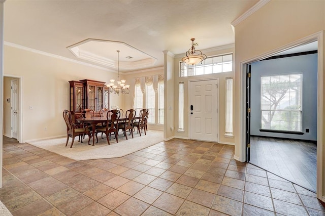 foyer featuring baseboards, a chandelier, ornamental molding, and a tray ceiling