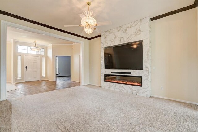 unfurnished living room with crown molding, a premium fireplace, carpet flooring, and baseboards