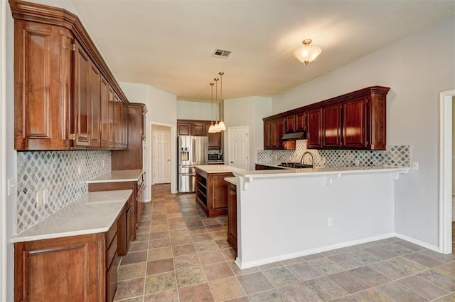 kitchen with stone finish floor, visible vents, appliances with stainless steel finishes, tasteful backsplash, and a peninsula
