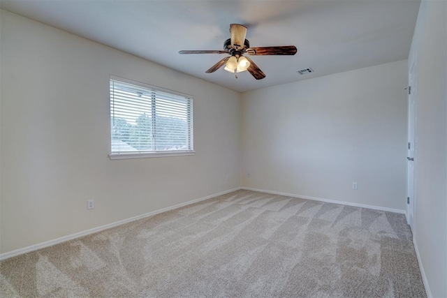 unfurnished room featuring baseboards, ceiling fan, visible vents, and light colored carpet