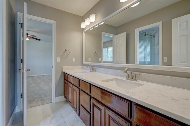 bathroom featuring a sink, baseboards, ceiling fan, and double vanity