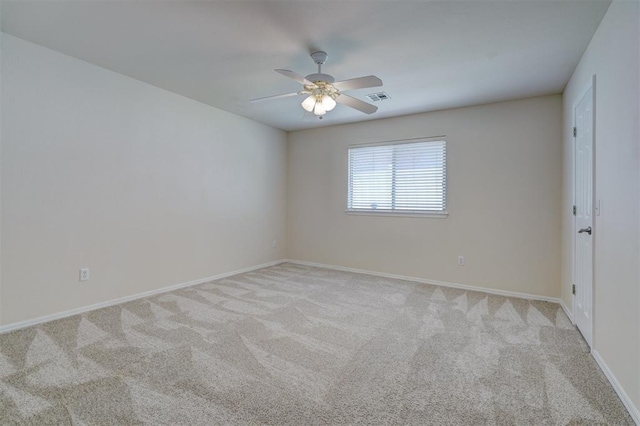 spare room featuring ceiling fan, visible vents, light carpet, and baseboards